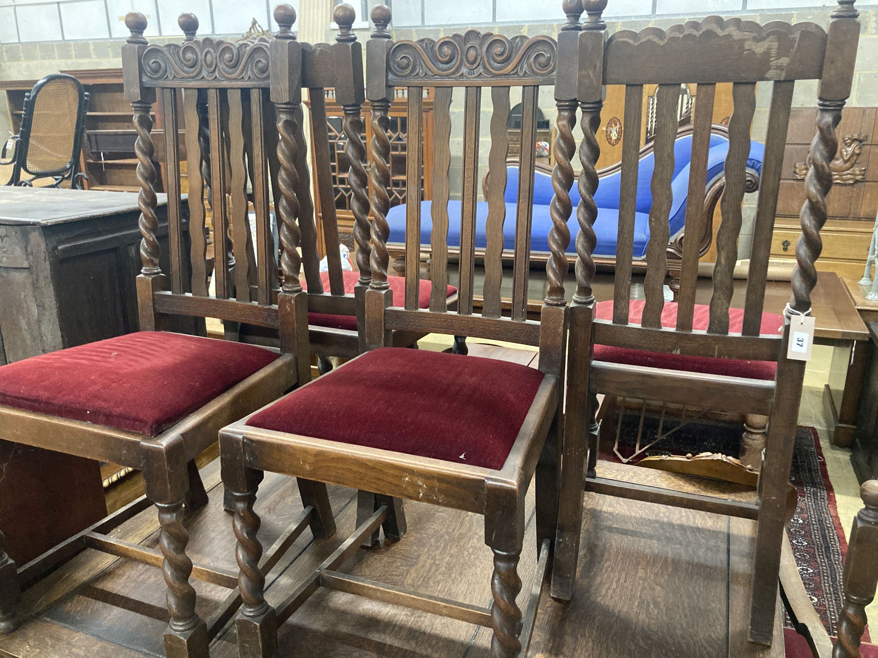 A set of six 1920s oak Carolean style dining chairs (two with arms) and an oak draw leaf dining table, width 137cm, depth 106cm, heigh